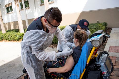 Firefighters in Protective Gear Checking Patients